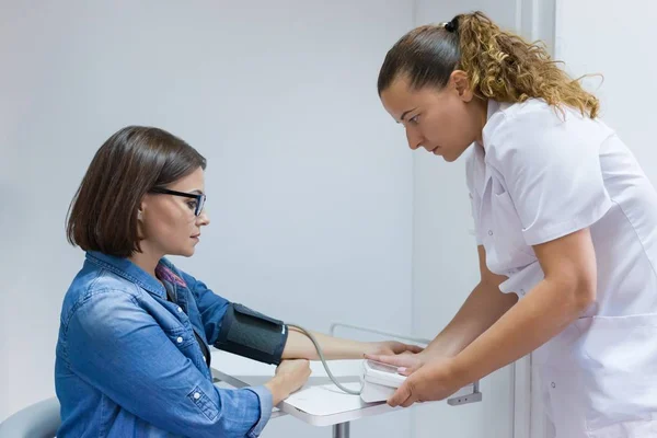 Sestro, přičemž žena pacientova krevního tlaku v úřadu — Stock fotografie