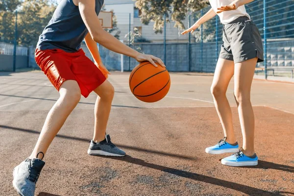 Streetball jogo de basquete com dois jogadores, adolescente menina e menino com bola, quadra de basquete da cidade ao ar livre . — Fotografia de Stock