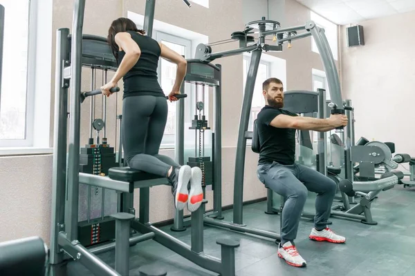 Gente haciendo ejercicios en simuladores en el gimnasio. Fitness, deporte, entrenamiento, personas, concepto de estilo de vida saludable — Foto de Stock