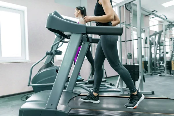 Deux jeunes femmes en bonne santé fitness sur tapis roulant dans le sport gymnase moderne. Fitness, sport, entraînement, concept de personnes — Photo