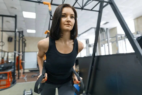 Gyönyörű fiatal nő az edzőteremben fitness pántokkal crossfit csinál. Sport, fitness, edzés, emberek koncepció — Stock Fotó