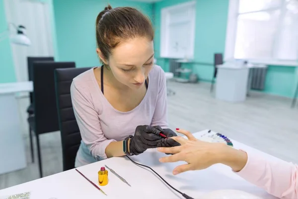 Prego e mão cuidados no salão de beleza. Jovem mulher fazendo manicure profissional — Fotografia de Stock