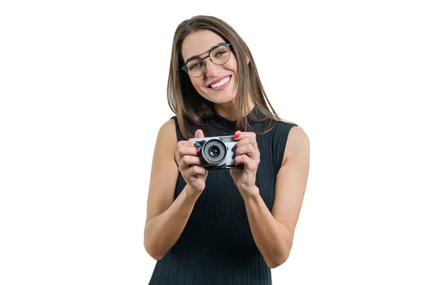 Jonge lachende mooie vrouw in zwarte jurk glazen bedrijf fotocamera in haar handen, het nemen van de foto, op witte geïsoleerde achtergrond — Stockfoto