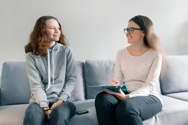 Jeune femme psychologue professionnelle parlant avec une adolescente de 14, 15 ans assise au bureau sur le canapé. Santé mentale de l'enfant à l'adolescence — Photo