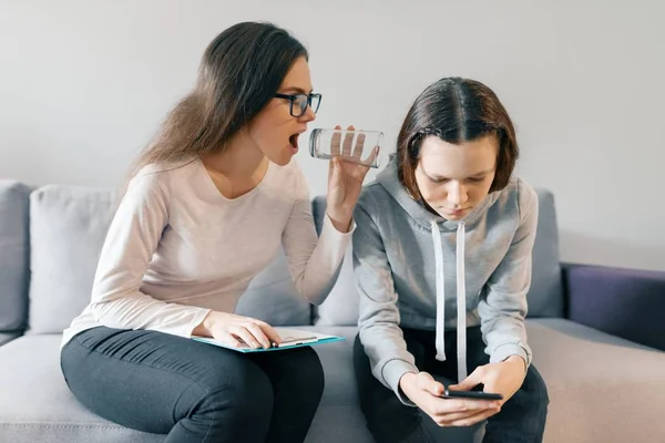 Adolescente patiente parlant avec un psychothérapeute professionnel au bureau. Fille regarde dans son téléphone ignore un psychologue — Photo