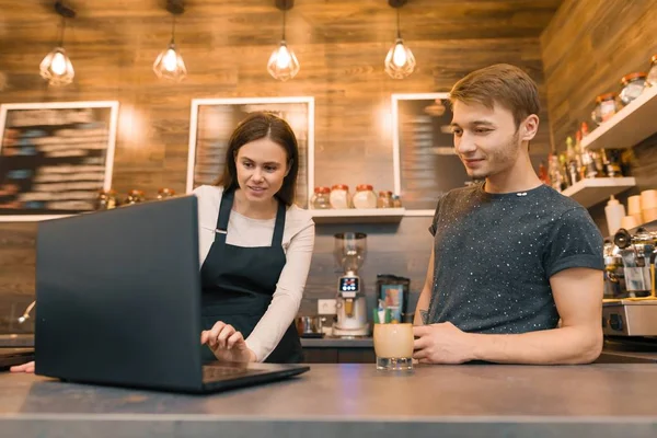 Equipe de trabalhadores da cafetaria que trabalham perto do balcão com computador portátil e fazendo café, negócio do café — Fotografia de Stock