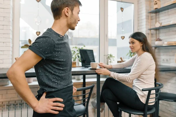 Interieur van Coffee Shop, jonge vrouw praten met café werknemer met kopje koffie aan tafel — Stockfoto