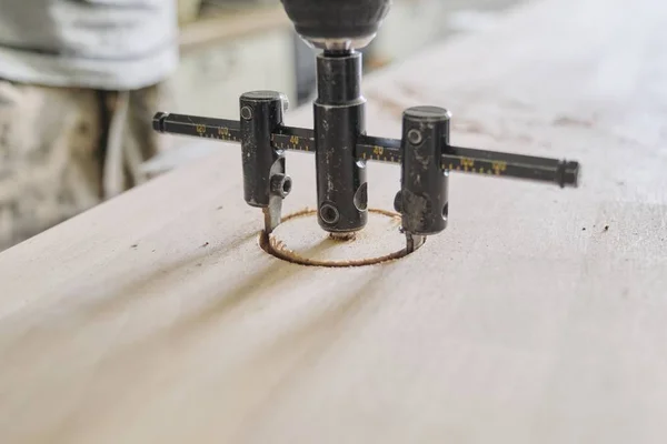 Close-up of carpenters hand using professional woodworking electric tools when working with wood. Male carving hole in wooden panel board, carpentry, woodwork, profession, people — Stock Photo, Image