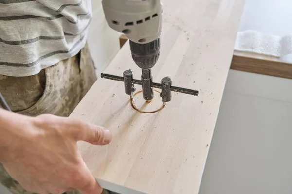 Närbild av snickare hand med hjälp av professionella träbearbetning elverktyg när man arbetar med trä. Manliga carving hål i trä panel ombord, snickeri, träarbeten, yrke, människor — Stockfoto