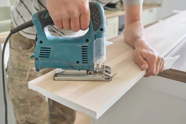 木材を使用する際にプロの木工電動工具を使用して大工の手のクローズアップ。木製パネルボード、大工、木工、職業、人々の男性の彫刻穴 — ストック写真