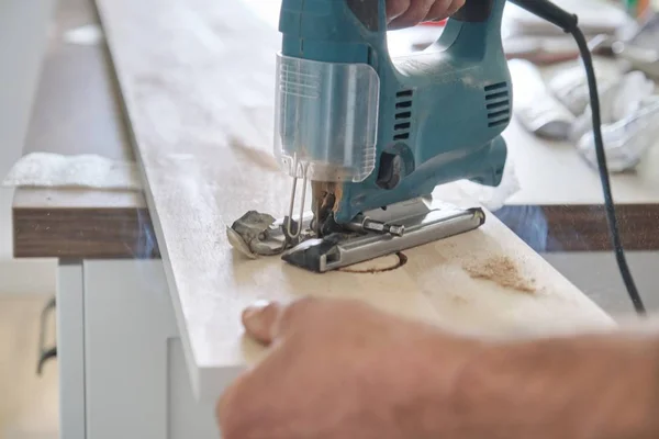 Close-up van timmerlieden hand met behulp van professionele houtbewerking elektrisch gereedschap bij het werken met hout. Mannelijke carving gat in houten paneel Board, timmerwerk, houtbewerking, beroep, mensen — Stockfoto