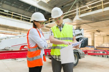 İnşaat bölgesinde adam mühendisi ve kadın mimarı. Bina, geliştirme, ekip çalışması ve insan konsepti