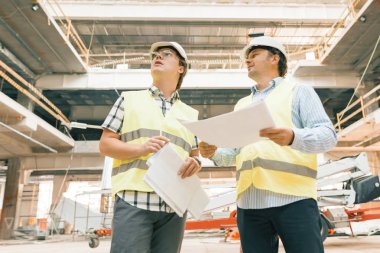 Kadın inşaat müfettişi şantiyeyi inceliyor. Bina, geliştirme, ekip çalışması ve insan konsepti