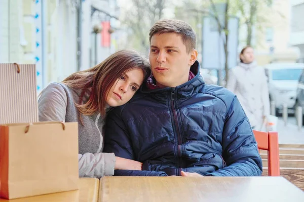 Junges müdes Paar mit Einkaufstaschen im Straßencafé, das auf Kaffee und Tee wartet — Stockfoto