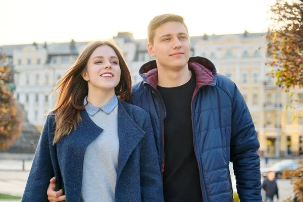 Retrato al aire libre de la feliz pareja abrazadora, hombre y mujer guapos caminando, fondo ciudad de la noche —  Fotos de Stock