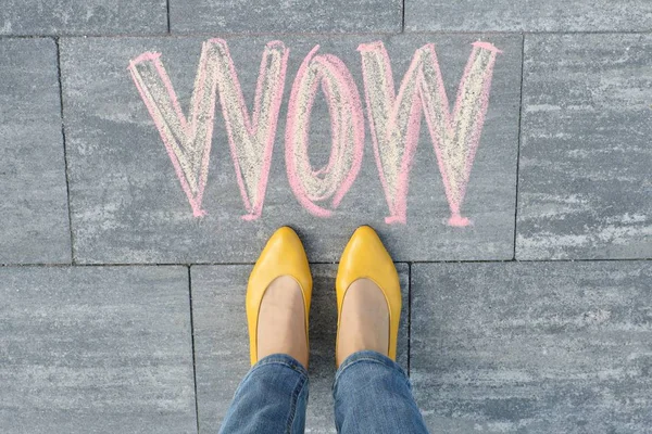 Wow escrito en la acera gris con piernas de mujer en los pies en zapatos amarillos — Foto de Stock