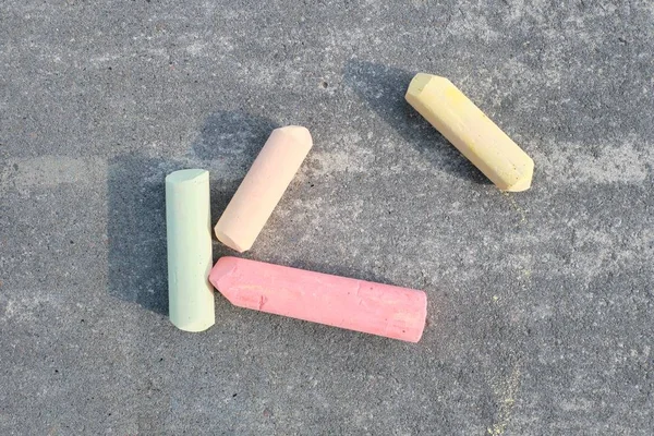 Colored chalk on gray asphalt, top view — Stock Photo, Image