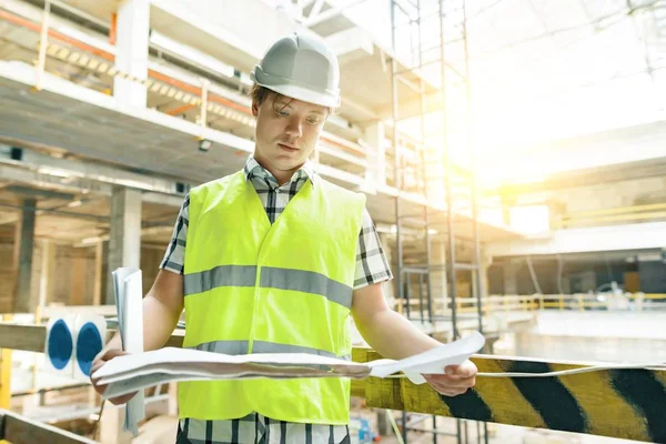 Retrato de constructor varón confiado, gerente, ingeniero con plan de construcción en el sitio de construcción. Construcción, concepto de desarrollo . — Foto de Stock