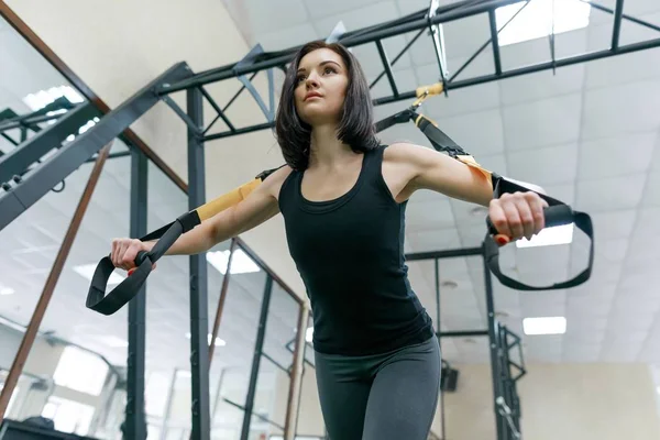 Young fitness woman doing exercises using the straps system in the gym. Sport, fitness, training, people concept. — Stock Photo, Image