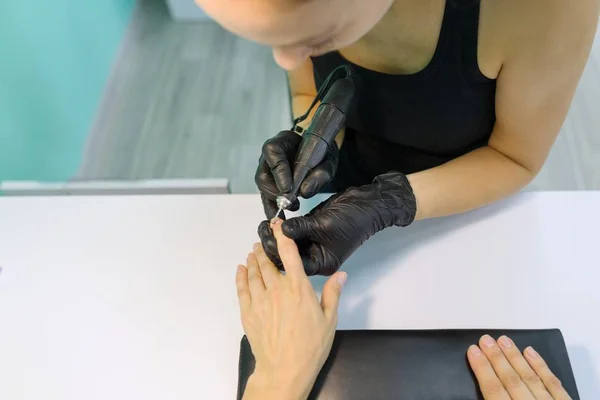 Processo de manicure close-up. Jovem mulher recebendo manicure profissional, salão de beleza, cuidados com as unhas . — Fotografia de Stock