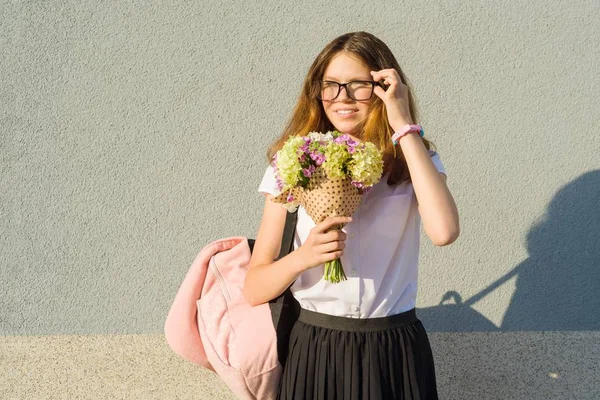 Retrato ao ar livre de menina adolescente usando óculos, com buquê de flores — Fotografia de Stock