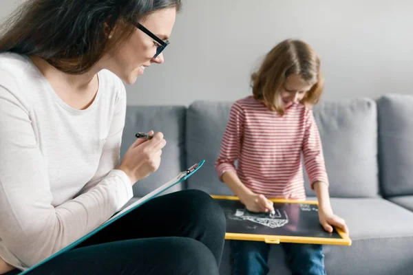 Giovane psicologa donna che parla con la paziente bambina in ufficio. Salute mentale dei bambini — Foto Stock