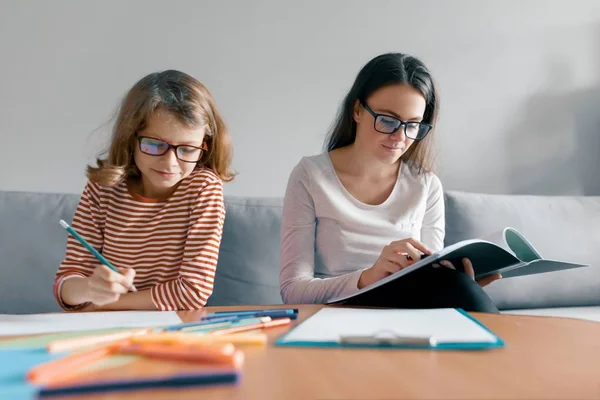 Fiatal tanárnőt, amely magán lecke gyerek, kislány ül asztalára írásban notebook — Stock Fotó