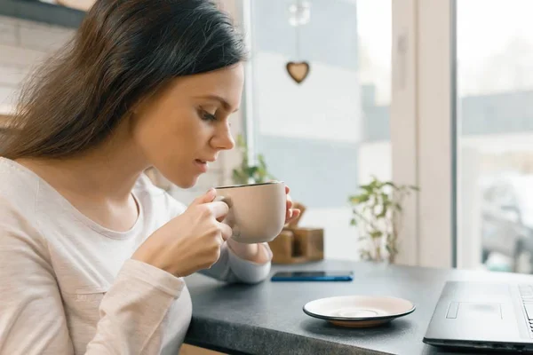 Primo piano della giovane bella donna di profilo con una tazza di caffè fresco in caffetteria — Foto Stock