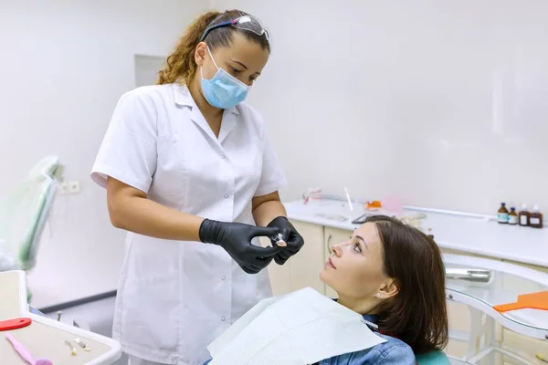 Prótesis parcial, mujer madura sentada en silla dental, médico dentista haciendo prótesis dental . — Foto de Stock