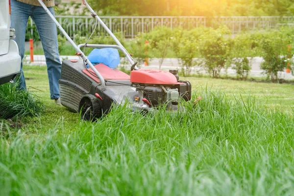 Lawn mower cutting green grass, gardener with lawnmower working — Stock Photo, Image