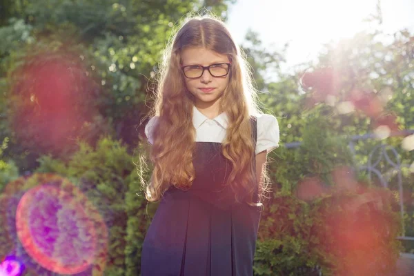 Retrato ao ar livre de menina bonita 7, 8 anos com óculos uniforme escolar — Fotografia de Stock