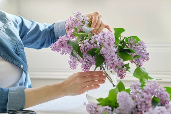 Vrouw maken boeket van lila takken, close-up vrouwelijke rangschikking bloemen bos in vaas — Stockfoto