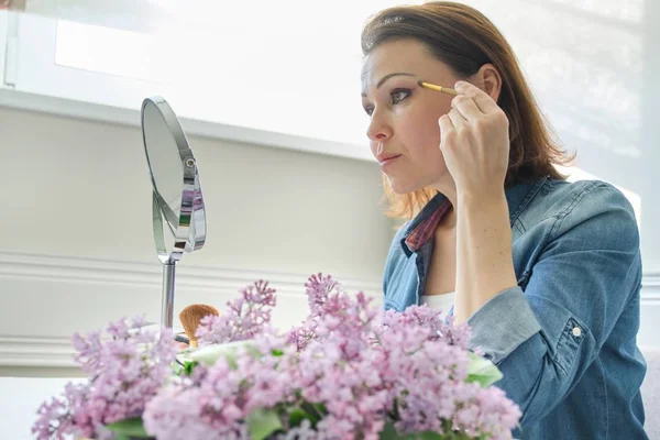 Portret van middelbare leeftijd vrouw met make-up spiegel, mooie vrouwelijke 40 jaar oud — Stockfoto