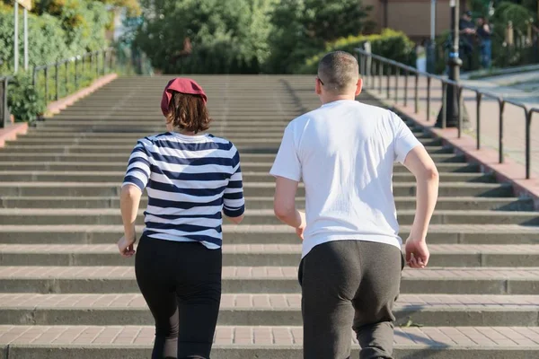 Actieve gezonde levensstijl van volwassen paar. Middelbare leeftijd man en vrouw lopen boven, uitzicht vanaf de achterkant — Stockfoto