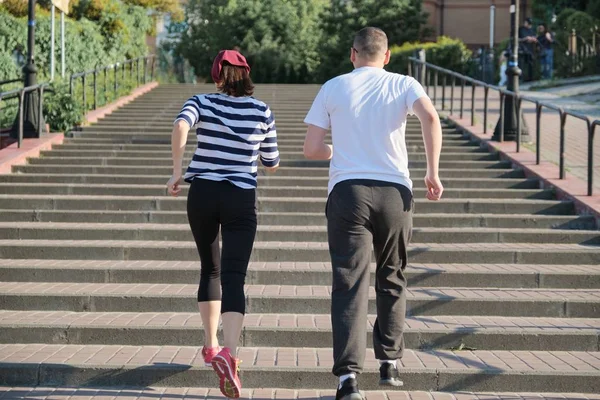 Aktív egészséges életmód az érett pár. Középkorú férfi és nő fut az emeleten, a kilátás a hátsó — Stock Fotó