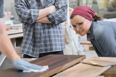 Woodworking workshop, worker varnishing wooden shelf closeup