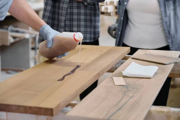 Primo piano della mano operaia in guanti protettivi con rivestimento protettivo per legno — Foto Stock