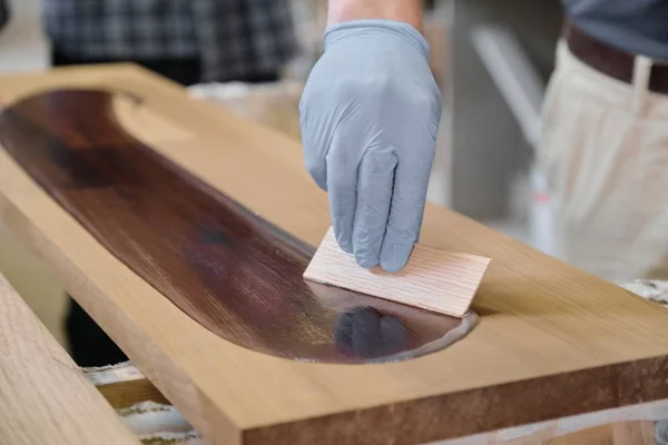 Closeup zaměstnanců na dřevěné prkně s povrchovou ochrannou ochranou pro dřevo — Stock fotografie