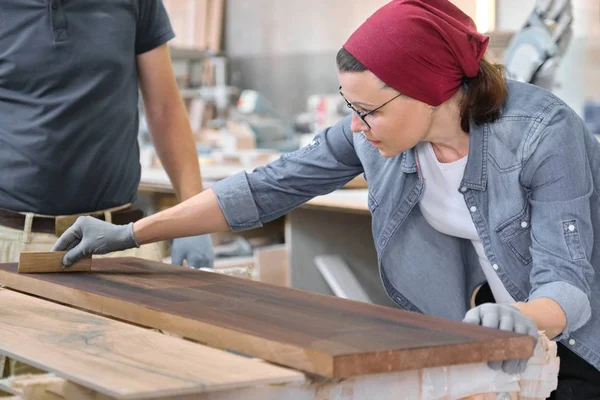 Artesana de mediana edad que trabaja en taller de carpintería. Tablero de madera barnizado femenino con aceite, barniz . — Foto de Stock