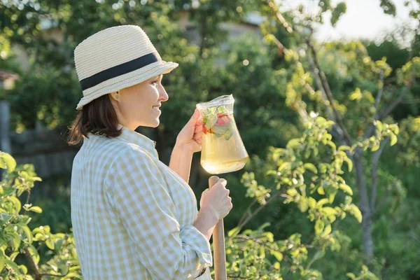 Retrato al aire libre de verano de mujer con bebida natural hecha de hierbas de menta de fresa, jardinería de mujer — Foto de Stock