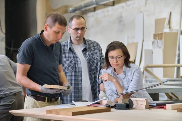 Team of carpenters workshop workers discussing a furniture project with client, designer, engineer. — Stock Photo, Image