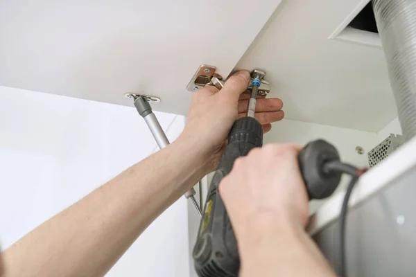 Proceso de primer plano de montaje de muebles de cocina, manos de trabajador masculino con herramientas profesionales —  Fotos de Stock