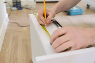 El işçi mobilya yapıyor, profesyonel araçları ile mutfak montajı closeup