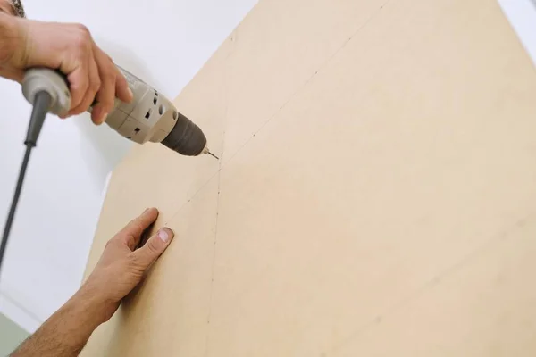 Installation of furniture. Closeup of workers hand with professional tools and furniture details