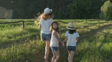 Bir köy yolunda yürüyen çocuklar şaşkın ve neşeli görünmek için yüzlerini çevirin.