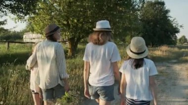 Kızlarıyla yürüyen anne, bir çocuğu kucaklayan kadın