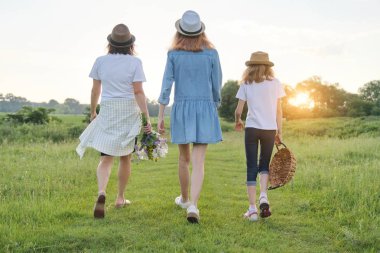 Çocuklu anne iki kızı bir ülke yolu üzerinde yürürken, geri görünümü