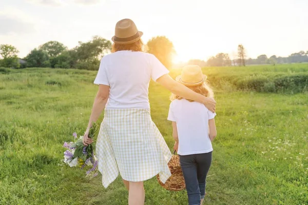 Madre e hija caminando por el prado, vista desde atrás — Foto de Stock