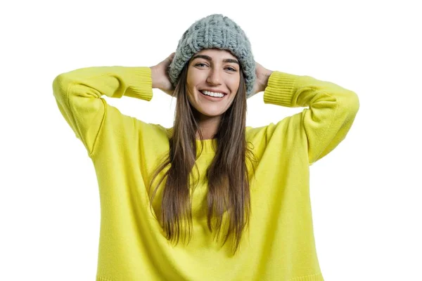 Jovem mulher bonita alegre em suéter amarelo e cinza grande loop de malha chapéu gorro olhando para a câmera no fundo isolado branco — Fotografia de Stock