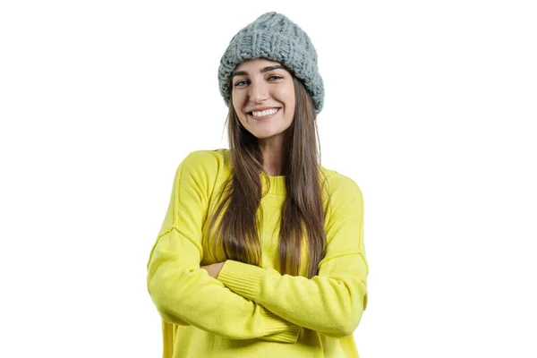 Jovem mulher bonita em suéter amarelo e cinza grande loop tricotado chapéu gorro, mãos dobradas, olhando para a câmera no fundo isolado branco — Fotografia de Stock